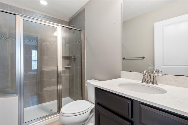 bathroom with walk in shower, vanity, and toilet