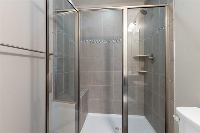 bathroom with an enclosed shower and toilet