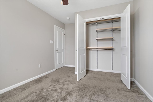 unfurnished bedroom with ceiling fan, a closet, and carpet