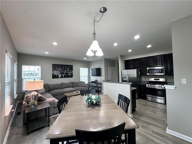 dining room with an inviting chandelier and light hardwood / wood-style flooring