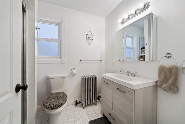 bathroom with toilet, a healthy amount of sunlight, vanity, and radiator heating unit