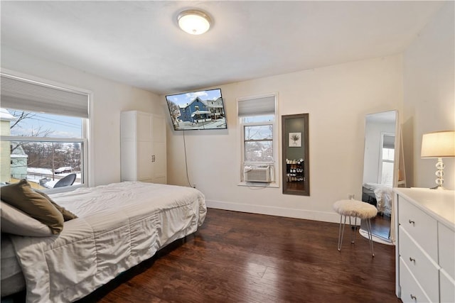 bedroom with cooling unit, dark hardwood / wood-style floors, and multiple windows