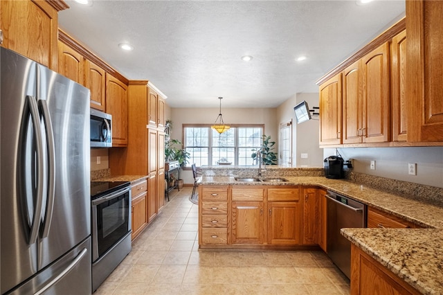 kitchen with decorative light fixtures, kitchen peninsula, sink, appliances with stainless steel finishes, and light stone counters