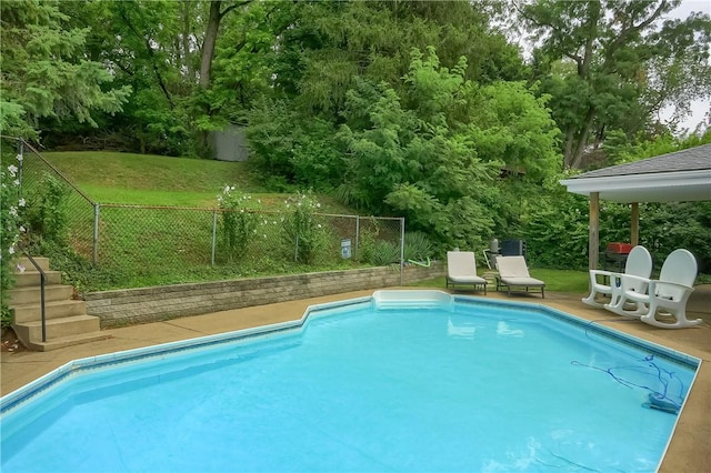 view of swimming pool with a yard