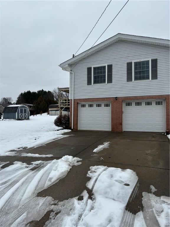 view of snow covered exterior featuring a garage