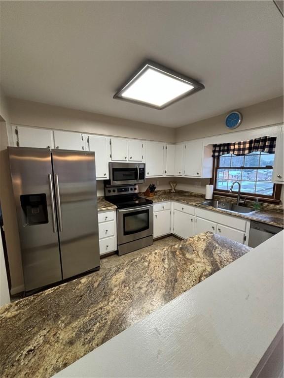 kitchen featuring sink, stainless steel appliances, and white cabinetry