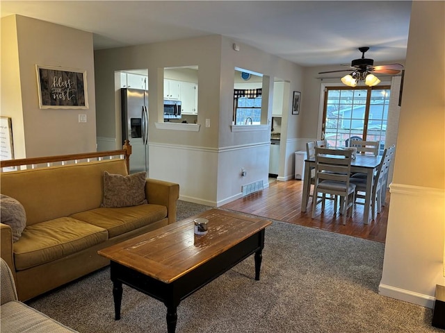 living room featuring ceiling fan and hardwood / wood-style flooring