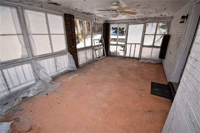 misc room with ceiling fan and brick wall