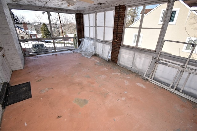 unfurnished sunroom featuring ceiling fan