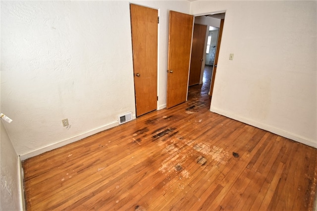 unfurnished room with hardwood / wood-style flooring