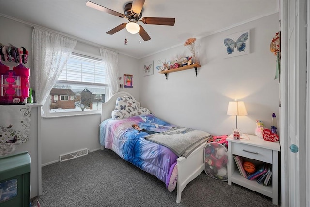 bedroom with ceiling fan, crown molding, and dark colored carpet