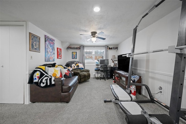 interior space featuring a textured ceiling, ceiling fan, and carpet