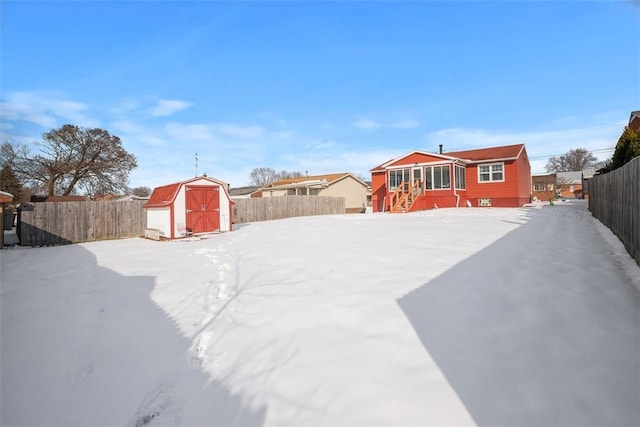 yard layered in snow featuring a storage shed