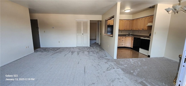 kitchen with carpet floors, a notable chandelier, sink, range with electric stovetop, and light brown cabinets