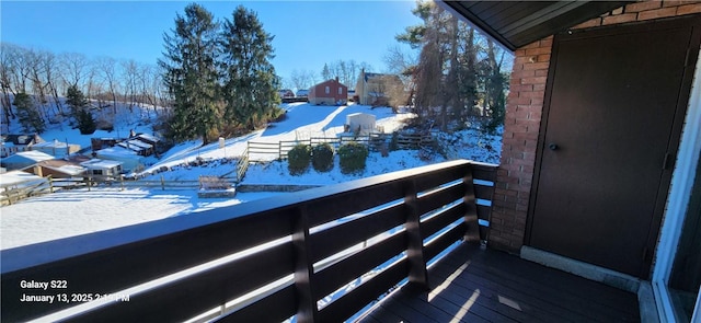 view of snow covered back of property