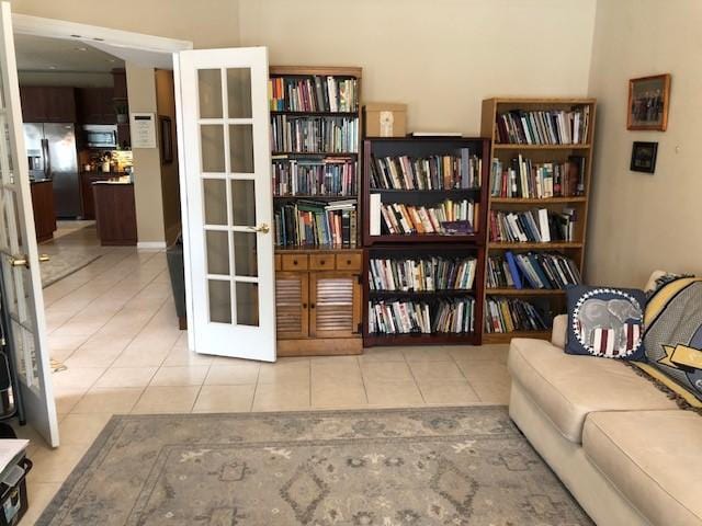 living area featuring french doors and light tile patterned flooring