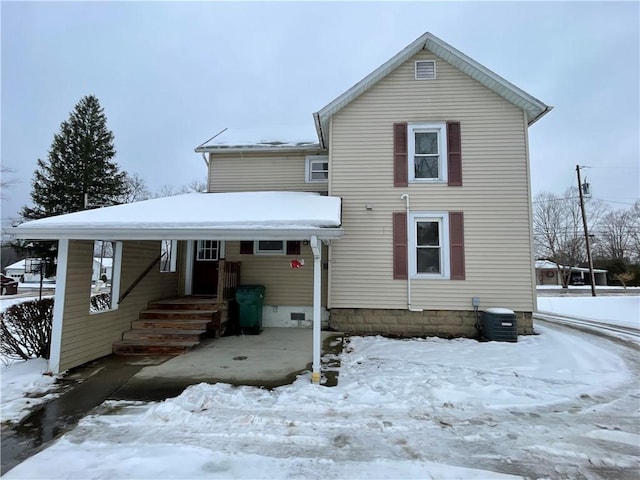 snow covered back of property with central AC unit