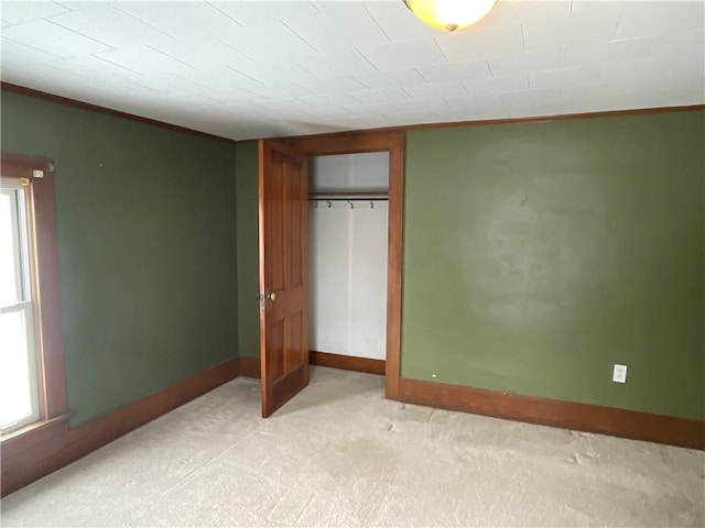 unfurnished bedroom featuring a closet and light colored carpet