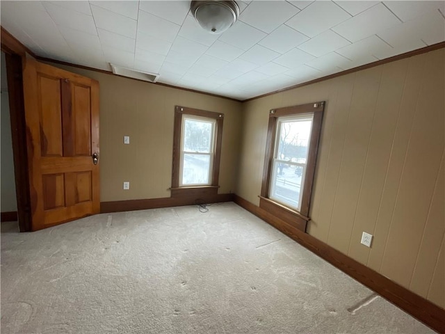 empty room featuring light colored carpet and ornamental molding