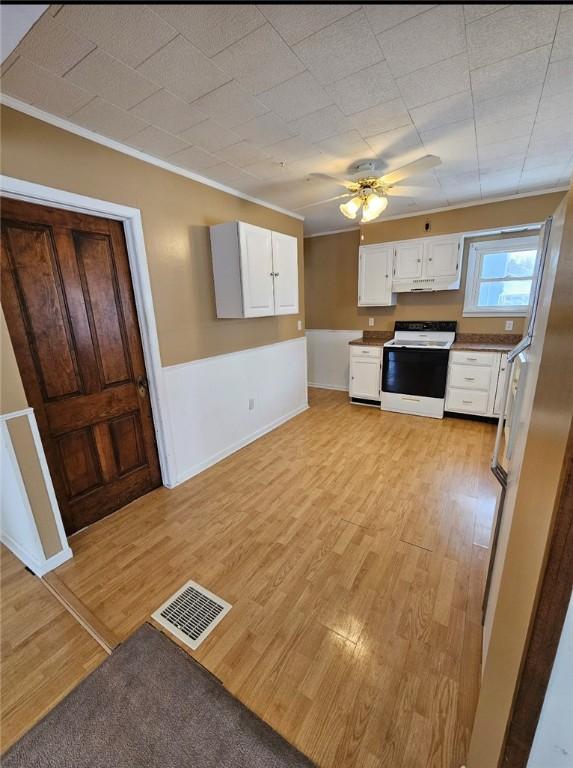 kitchen featuring white cabinetry, ornamental molding, range with electric cooktop, and light wood-type flooring