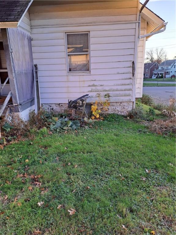 view of side of home with a yard