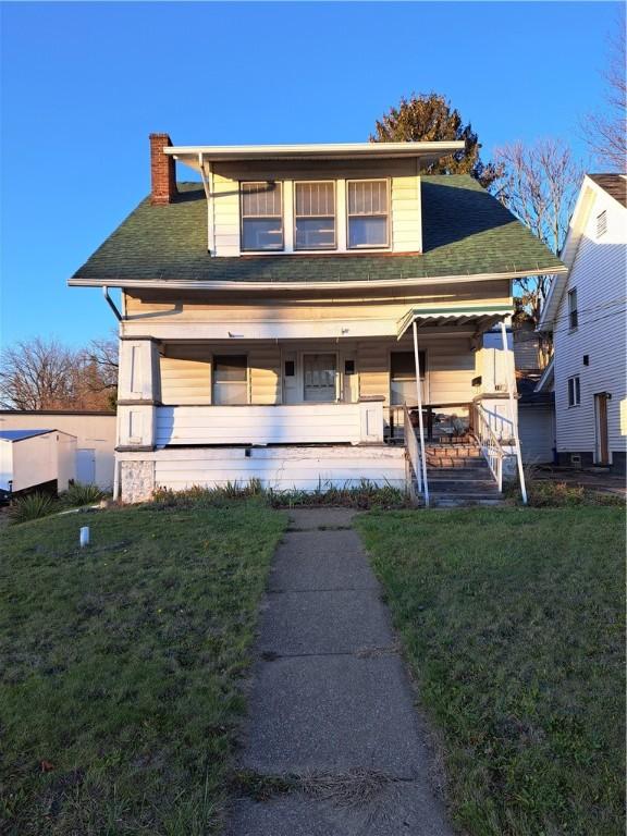 view of front of property with covered porch and a front lawn