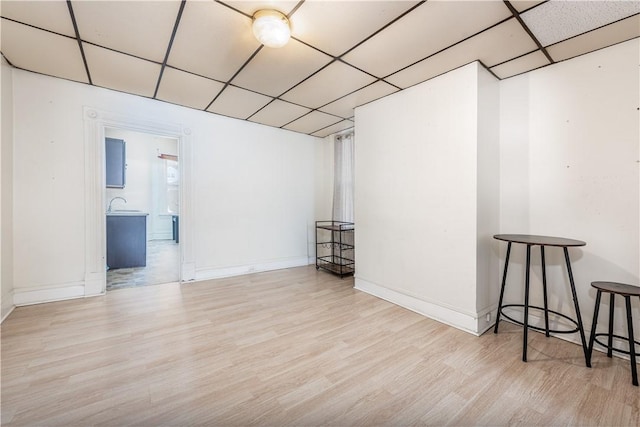 interior space with a paneled ceiling, light hardwood / wood-style flooring, and sink