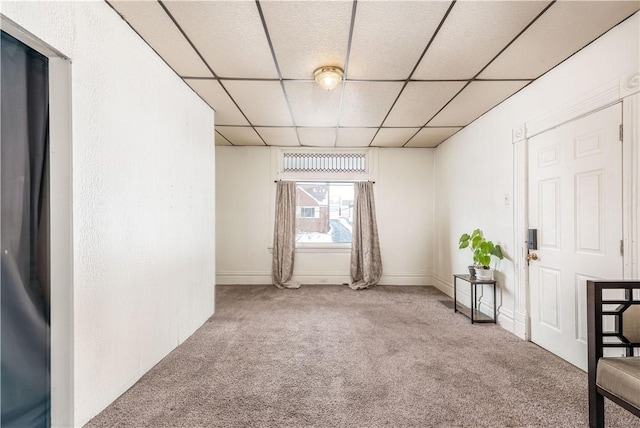 carpeted spare room with a paneled ceiling