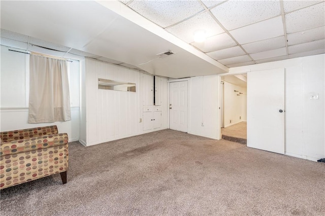 basement with a drop ceiling and carpet flooring