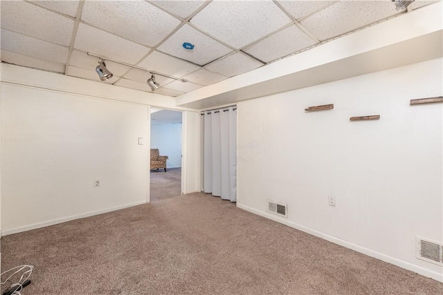 carpeted spare room with a drop ceiling and rail lighting