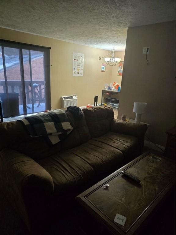 living room with a textured ceiling, a chandelier, and a wall mounted AC