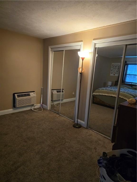 bedroom featuring a wall unit AC and carpet floors