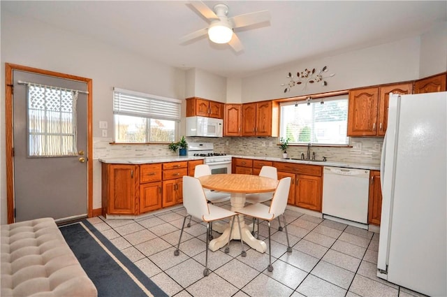 kitchen featuring ceiling fan, sink, white appliances, and decorative backsplash