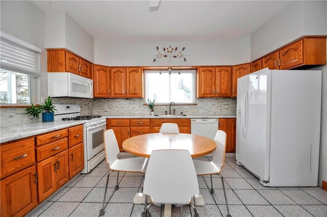 kitchen with sink, white appliances, and backsplash