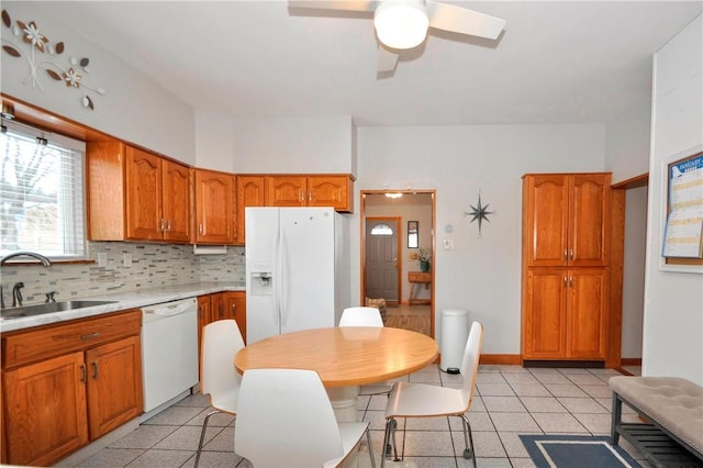 kitchen with ceiling fan, backsplash, sink, and white appliances