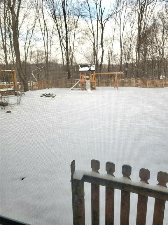 yard layered in snow featuring a playground