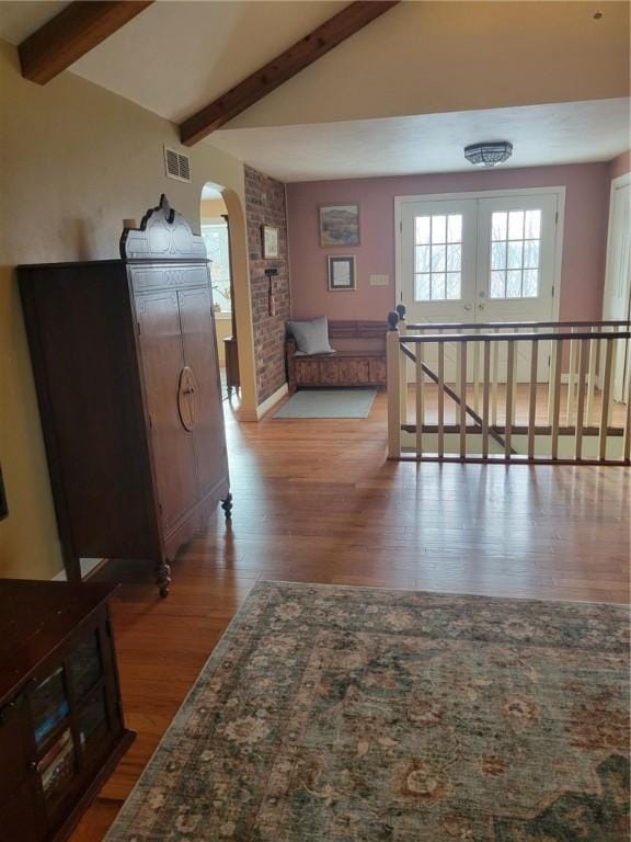 hallway with lofted ceiling with beams and hardwood / wood-style floors