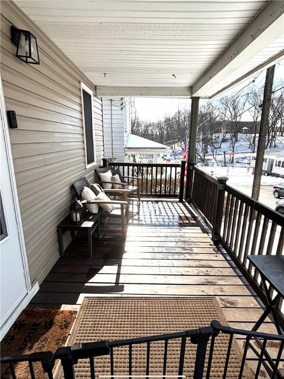 snow covered deck with a porch