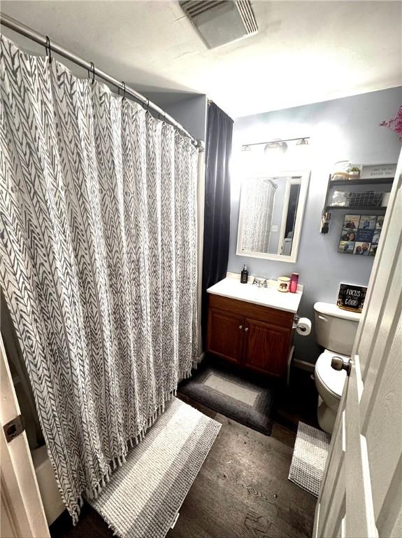 bathroom featuring vanity, curtained shower, and toilet