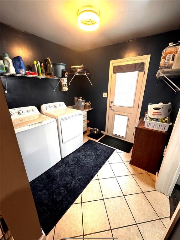 washroom featuring washing machine and dryer and light tile patterned flooring