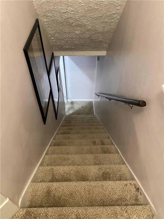 stairs with a textured ceiling