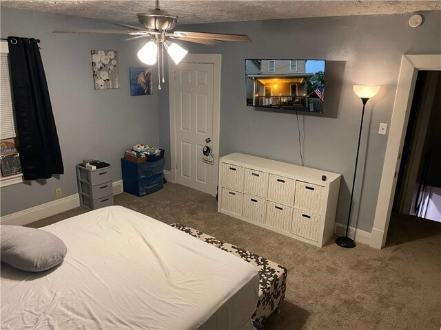 bedroom featuring ceiling fan, a textured ceiling, and dark colored carpet