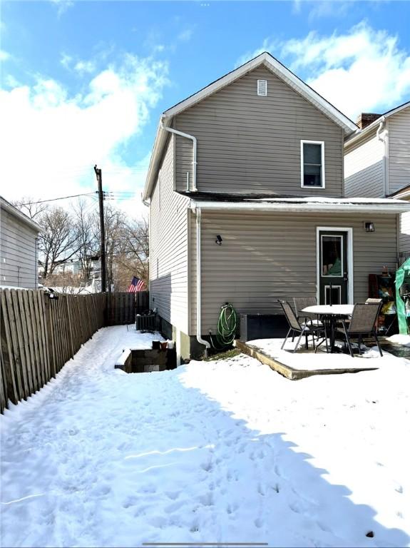 view of snow covered back of property