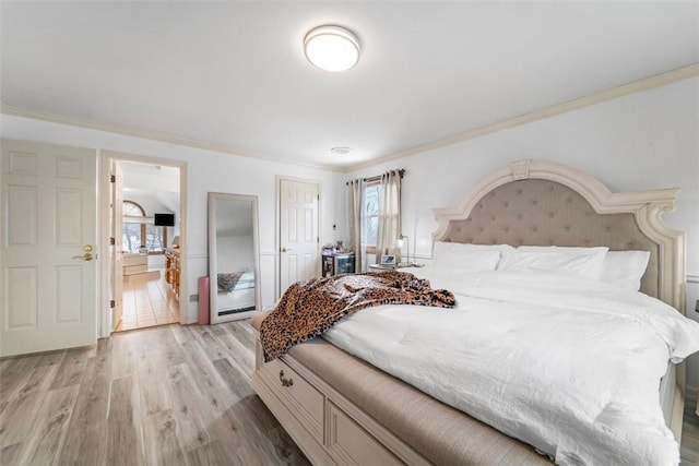 bedroom featuring ensuite bathroom, light wood-type flooring, crown molding, and multiple windows