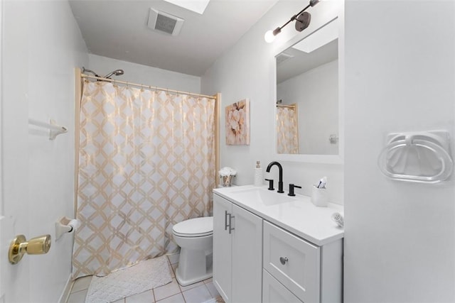 bathroom featuring toilet, vanity, and tile patterned flooring