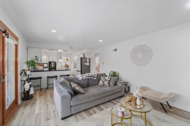 living room featuring light wood-type flooring and a wealth of natural light