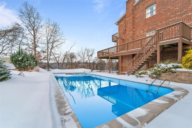 snow covered pool with a wooden deck