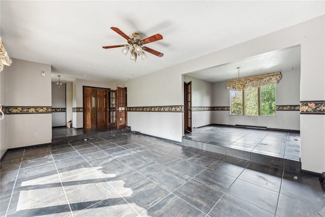 unfurnished room featuring ceiling fan with notable chandelier and a baseboard radiator