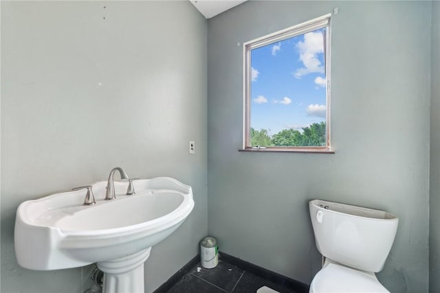 bathroom with toilet, tile patterned floors, and sink