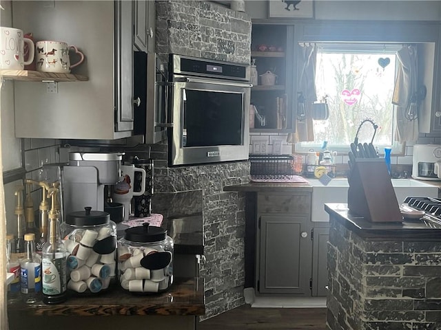 kitchen featuring dark hardwood / wood-style flooring, gray cabinets, and oven